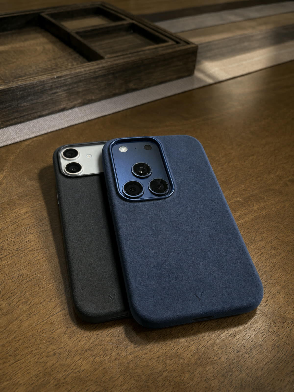 Navy and graphite Virela iPhone 17 cases in soft window light